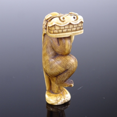 270 - A 19th century Japanese ivory netsuke, monkey carrying a dragon mask, signed, height 5cm