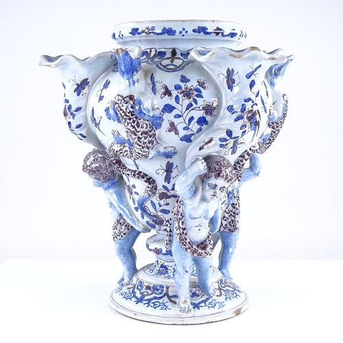 315 - A Delft tin glazed pottery vase, supported by Classical figures, with hand painted decoration, heigh... 