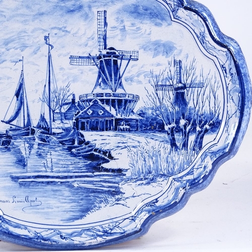 317 - A Delft blue and white pottery wall plaque, with painted canal scene, 39cm across