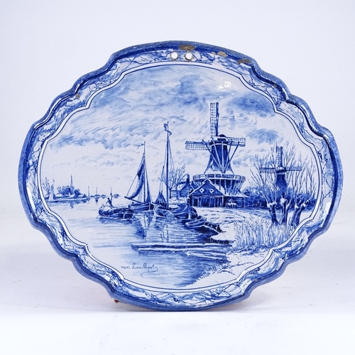 317 - A Delft blue and white pottery wall plaque, with painted canal scene, 39cm across