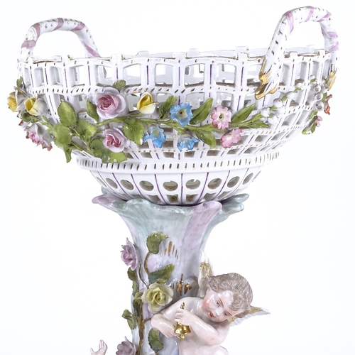 338 - A German porcelain basket on stand, supported by 2 cherubs, height excluding handles 35cm