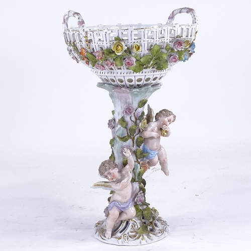 338 - A German porcelain basket on stand, supported by 2 cherubs, height excluding handles 35cm