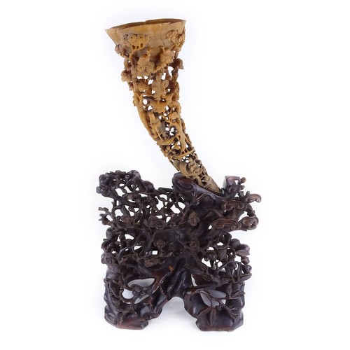 300 - A 19th century Chinese rhinoceros horn full tip cup, carved and pierced all over with Oriental figur... 