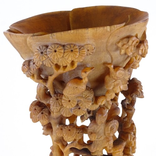 300 - A 19th century Chinese rhinoceros horn full tip cup, carved and pierced all over with Oriental figur... 