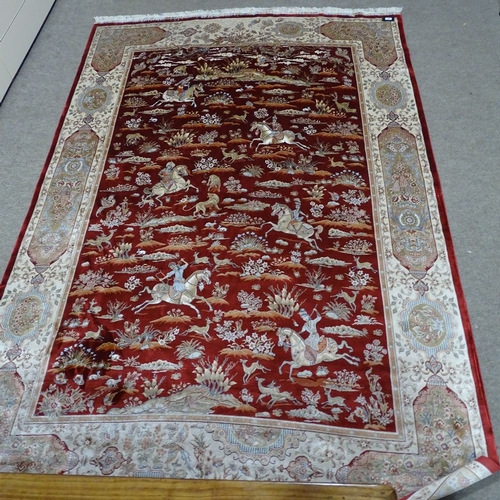 357 - A finely woven Middle Eastern red ground silk rug, depicting hunting scenes