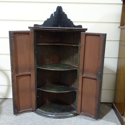 82 - A 19th century bow-front 2-door hanging corner cupboard, with painted religious scene, height to top... 