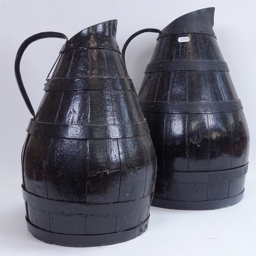 3 - A large graduated pair of black painted coopered oak water flagons, largest height 47cm