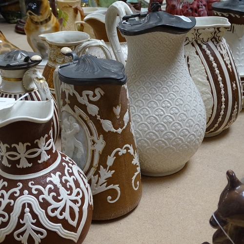 351 - A group of 19th century embossed pottery jugs, some with pewter lids (11)