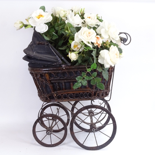 38 - A reproduction stained bentwood child's pram, filled with a display of fake flowers