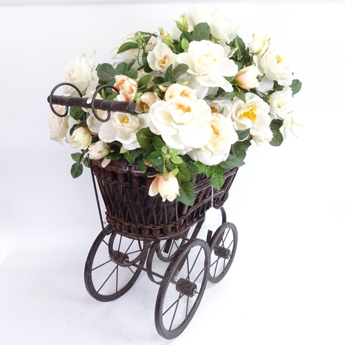 38 - A reproduction stained bentwood child's pram, filled with a display of fake flowers