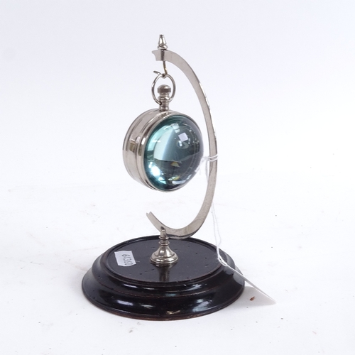 383 - A reproduction nickel and glass-cased ball clock on stand