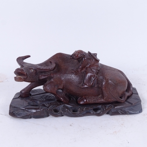 586 - A carved and stained wood buffalo and rider, on original hardwood stand, early 20th century