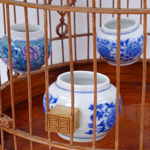 747 - A decorative Oriental bird cage with ceramic pots, height 43cm