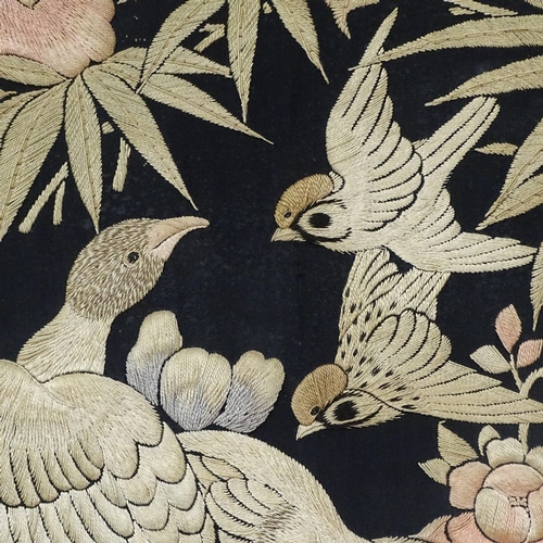 765 - A mounted embroidered panel, depicting flowers and birds, being a panel from a Japanese kimono, heig... 