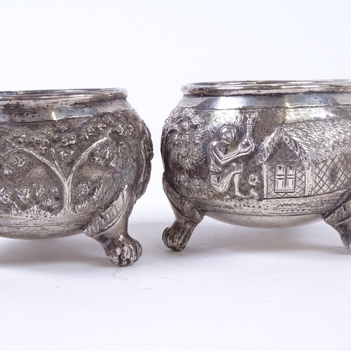 876 - A pair of embossed white metal salts, an Indian white metal napkin ring, and 3 hammered white metal ... 