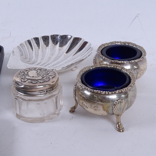 925 - A group of silver items, to include a cased set of 6 silver coffee spoons, a pair of salts, shell di... 