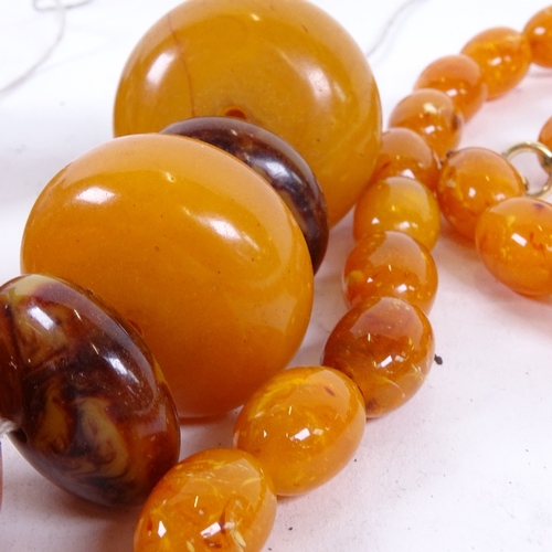 930 - A graduated string of large simulated polished amber beads, largest bead length 39.8mm, and a string... 