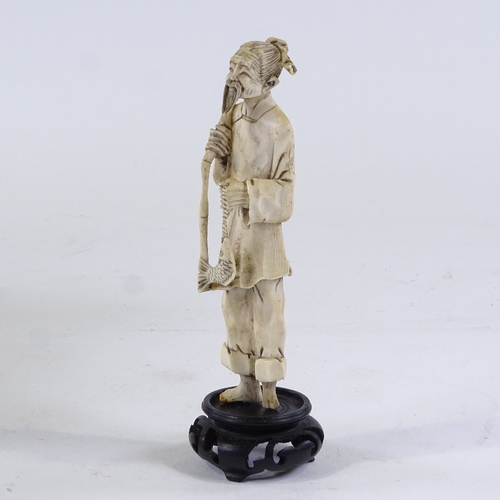 232 - A Japanese carved ivory fisherman, Meiji Period, circa 1900 to 1920, on wooden stand, overall height... 