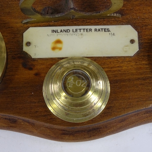 279 - A set of brass postal scales and weights, with plaque displaying inland letter rates, length 24cm