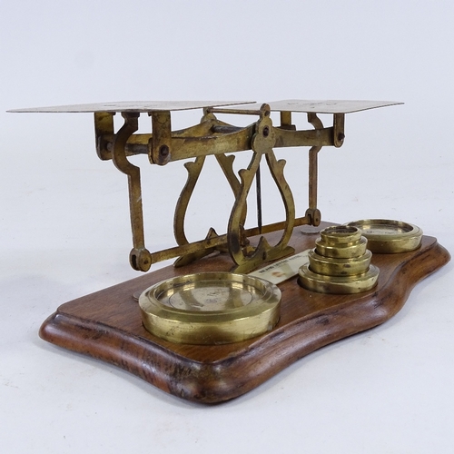 279 - A set of brass postal scales and weights, with plaque displaying inland letter rates, length 24cm