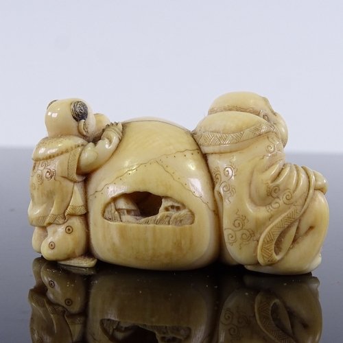 293 - A Japanese ivory netsuke in the form of a man and child resting on a sack, Meiji Period, length 4cm