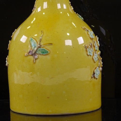 323 - A Chinese yellow glaze narrow-neck vase, with relief  prunus design, height 18cm