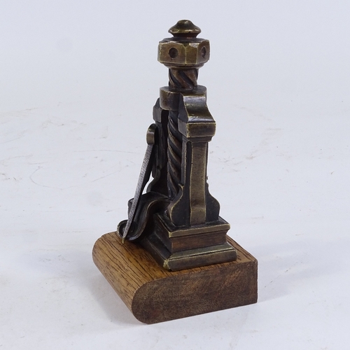 336 - A patinated bronze desk paperweight in the form of a book press, on wood plinth, height 15cm