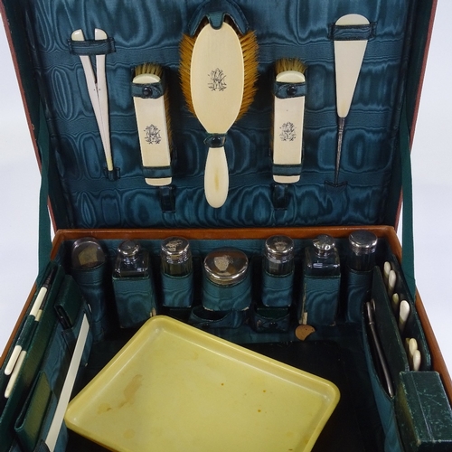 66 - A gentleman's leather travelling case, the interior fitted with original silver-topped cut-glass toi... 