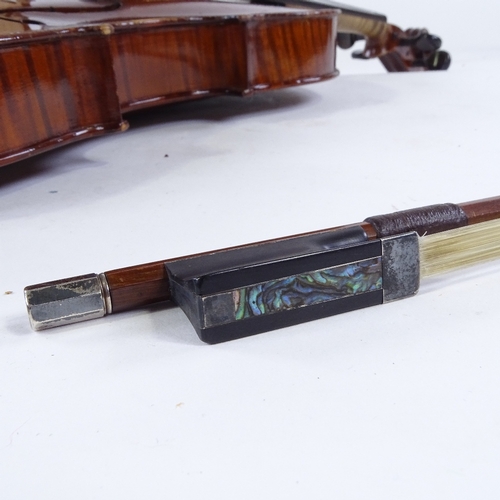 96 - A silver-mounted violin bow, by Adam Heinrich, together with an unnamed early 20th century violin, w... 