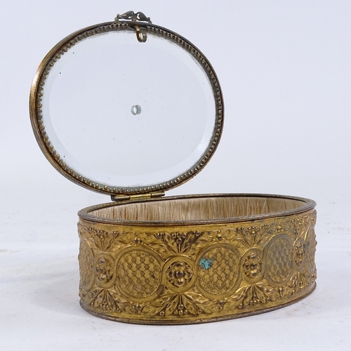 403 - A 19th century oval gilt-metal trinket box with bevel-glass panelled hinged lid, length 13.5cm