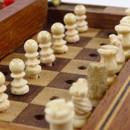 430 - A small mahogany travelling chess set, with red and white stained bone pieces, length 13cm