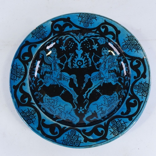 441 - An Islamic blue ground glazed pottery bowl, decorated with hunting scenes, diameter 30cm