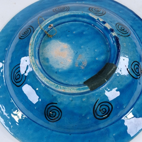 441 - An Islamic blue ground glazed pottery bowl, decorated with hunting scenes, diameter 30cm