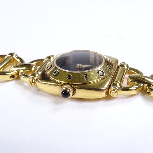 514 - GUCCI - a lady's gold plated 6400L quartz wristwatch, circa 1997, black dial with gilt hands and cab... 