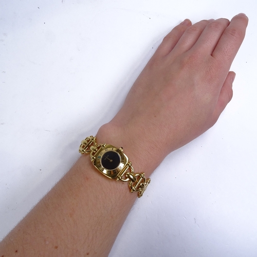 514 - GUCCI - a lady's gold plated 6400L quartz wristwatch, circa 1997, black dial with gilt hands and cab... 