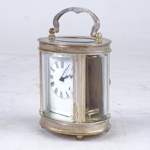 543 - A small oval silver plated carriage clock, white enamel dial with Roman numeral hour markers and cur... 