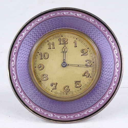 545 - An early 20th century purple enamel and unmarked white metal-framed 8-day circular mantel clock, cha... 