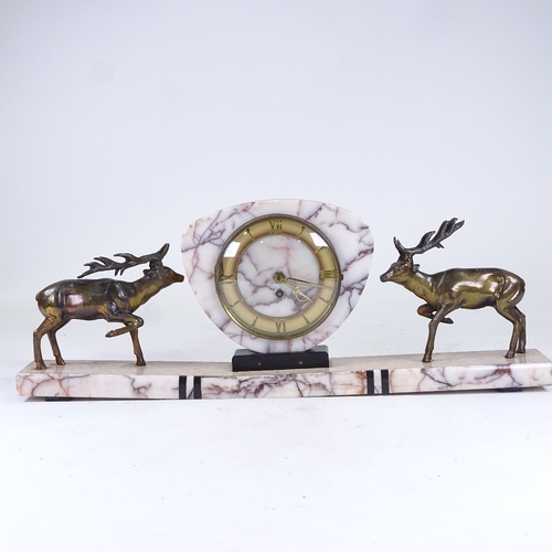 548 - An Art Deco pink veined marble 30-hour mantel clock, surmounted by 2 spelter stags, with brass chapt... 