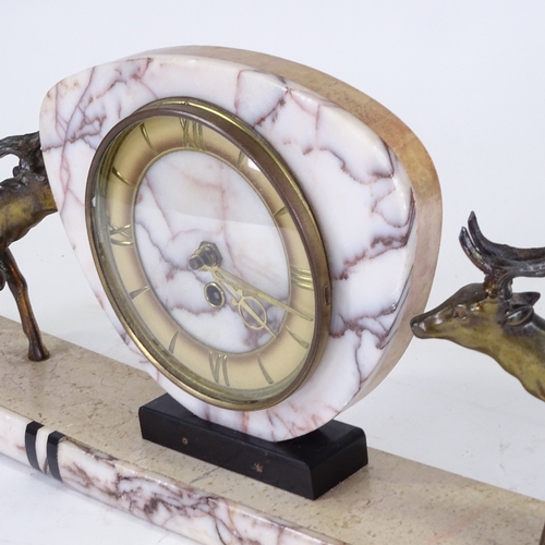 548 - An Art Deco pink veined marble 30-hour mantel clock, surmounted by 2 spelter stags, with brass chapt... 