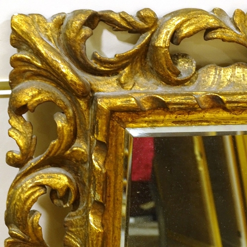 117 - An ornate carved and pierced giltwood-framed Rococo style wall mirror, overall dimensions 78cm x 67c... 