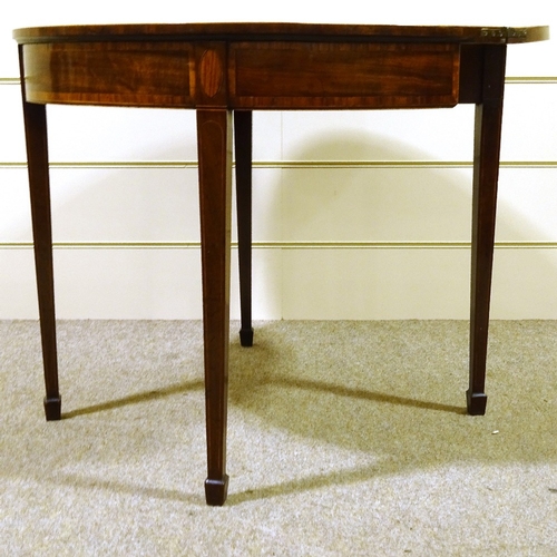 413 - A George III mahogany demilune fold over card table, with tapered legs and spade feet