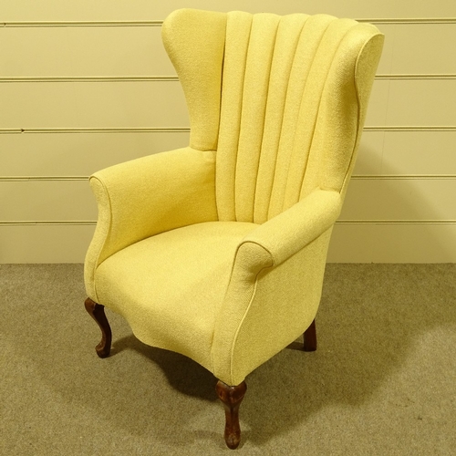 94 - An Art Deco upholstered wing armchair, circa 1930s, recently re-upholstered in pale gold fabric, on ... 