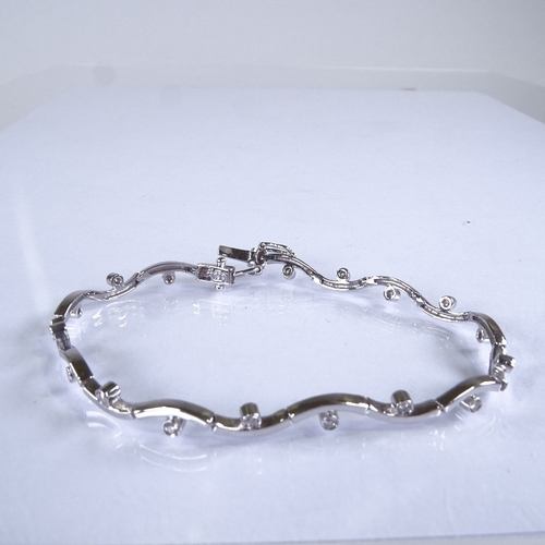 590 - A modern 18ct white gold diamond line bracelet, total diamond content approx 0.35ct, bracelet length... 