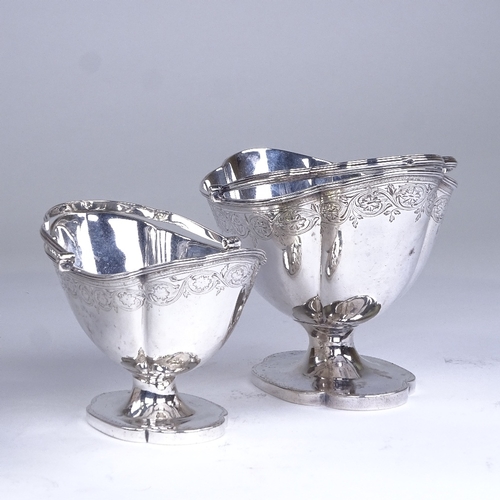 630 - A graduated pair of George III silver boat-shaped pedestal sugar baskets, reeded swing handles with ... 