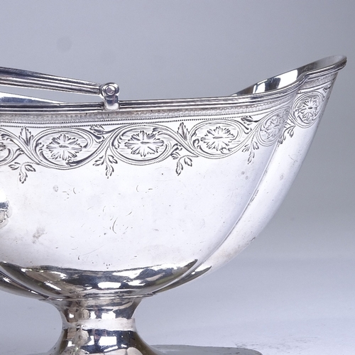 630 - A graduated pair of George III silver boat-shaped pedestal sugar baskets, reeded swing handles with ... 