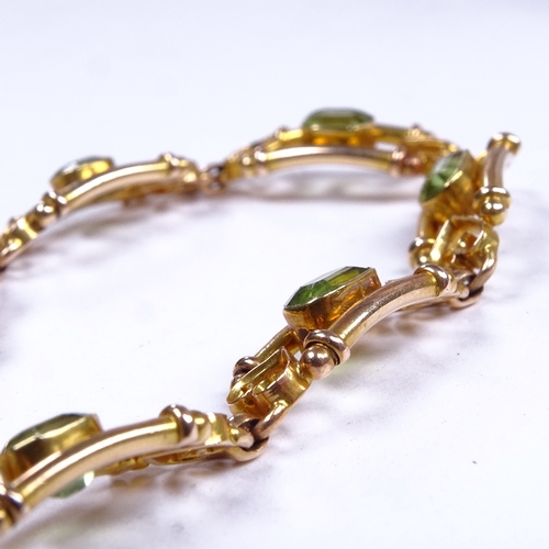 646 - An Art Nouveau 15ct gold peridot bracelet, emerald-cut peridots flanked by tube boarder and scrolled... 