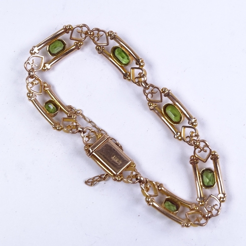 646 - An Art Nouveau 15ct gold peridot bracelet, emerald-cut peridots flanked by tube boarder and scrolled... 