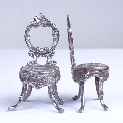 664 - A pair of miniature silver doll's house chairs, allover relief embossed and engraved foliate decorat... 