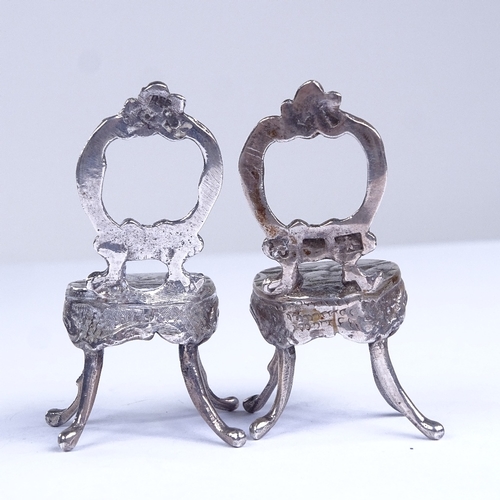 664 - A pair of miniature silver doll's house chairs, allover relief embossed and engraved foliate decorat... 