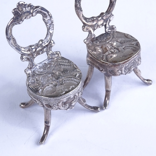 664 - A pair of miniature silver doll's house chairs, allover relief embossed and engraved foliate decorat... 